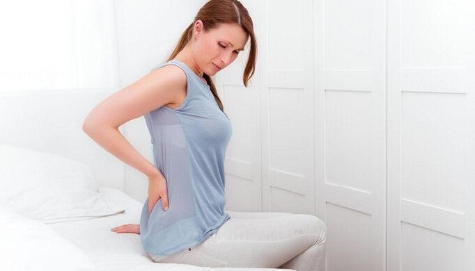 Una mujer está preocupada por el dolor de espalda.